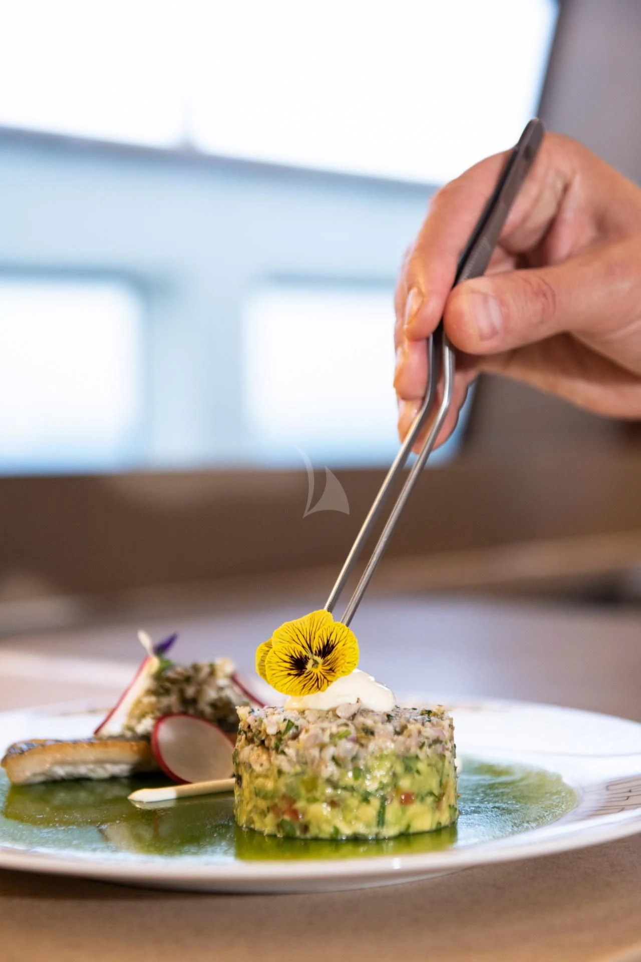 a person holding a spoon over a plate of food aboard VELA Yacht for Sale