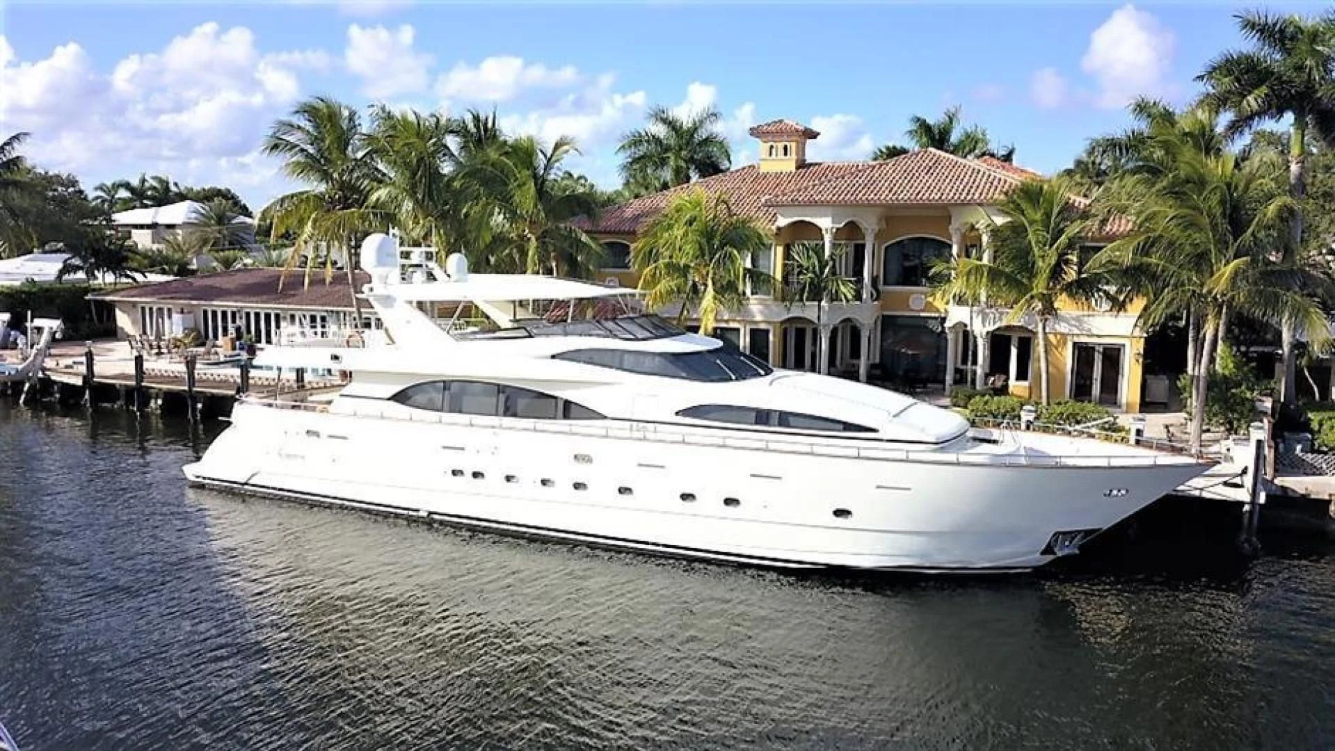 a white yacht docked at a pier aboard CAROBELLE Yacht for Sale