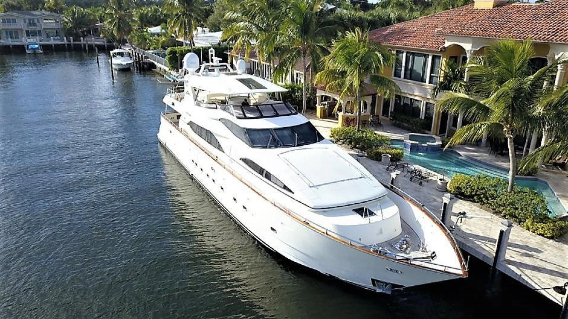 a white boat docked at a pier aboard CAROBELLE Yacht for Sale