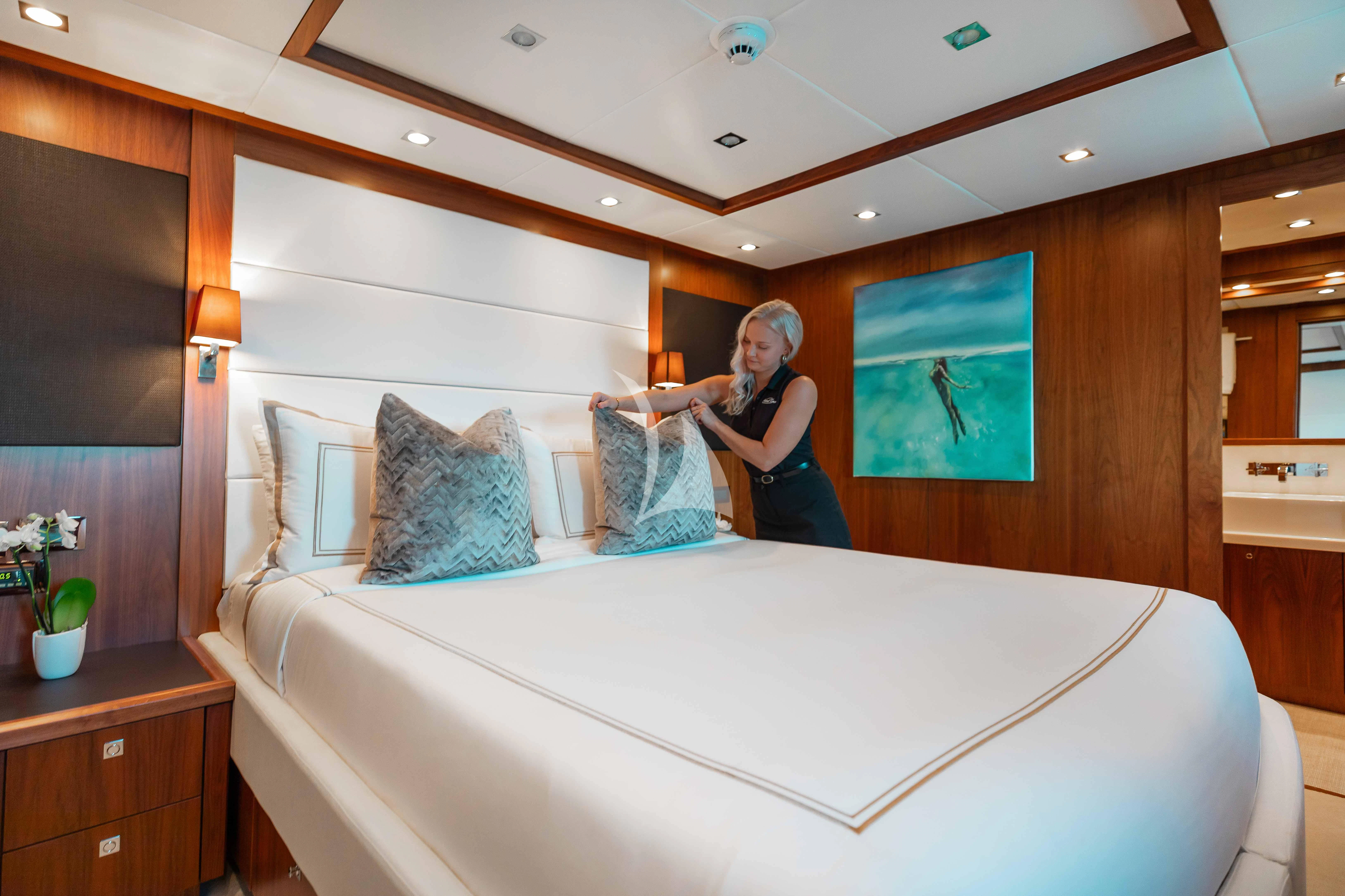 a person standing next to a bed aboard ABOUT TIME Yacht for Sale
