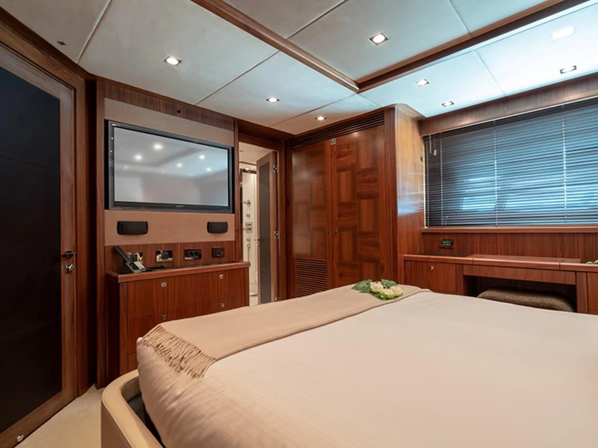 a bedroom with a bed and tv aboard ABOUT TIME Yacht for Sale