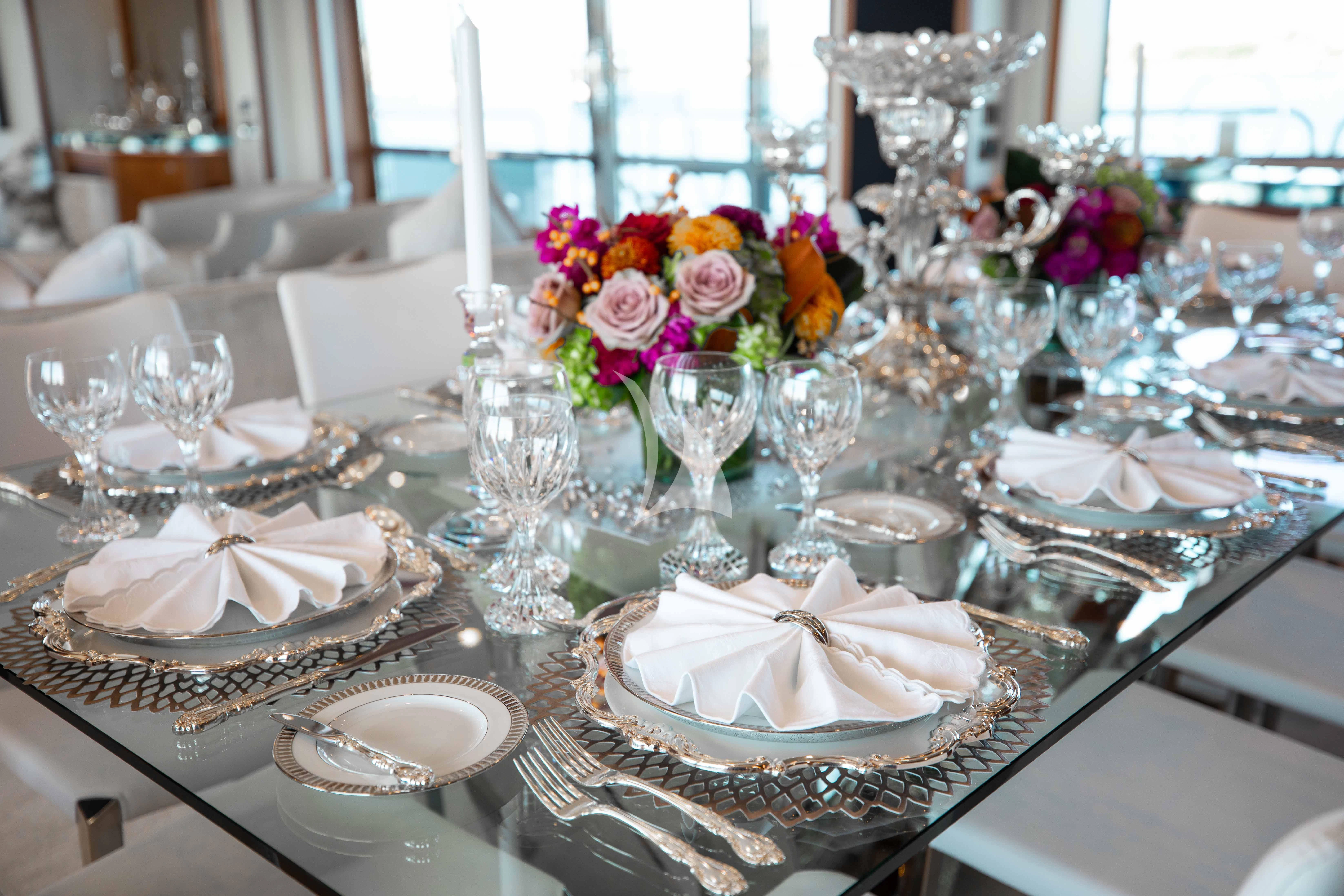 a table with plates and glasses aboard ABOUT TIME Yacht for Sale