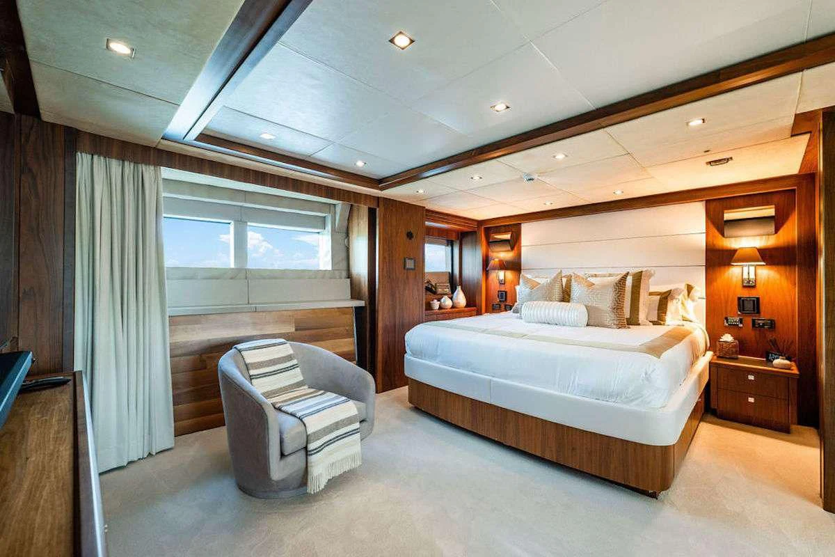 a bedroom with a bed and a chair aboard ABOUT TIME Yacht for Sale