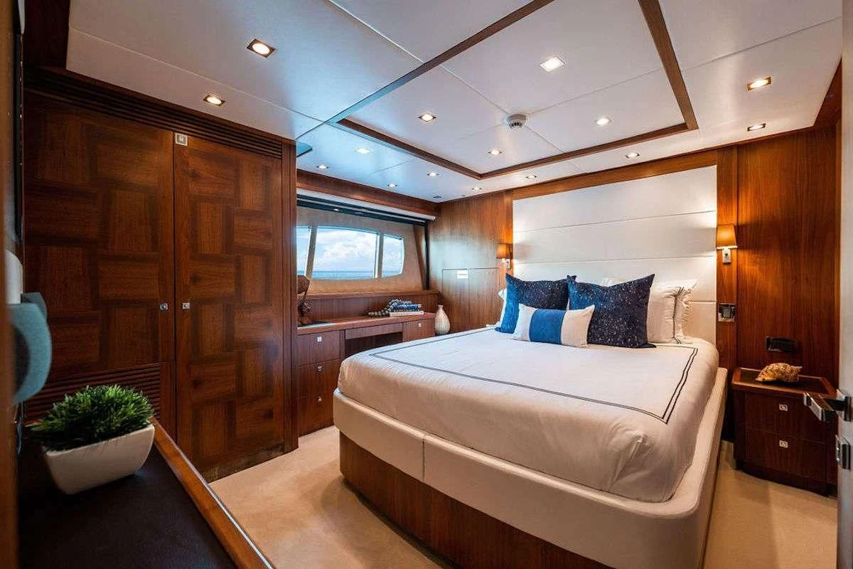 a bedroom with a bed and a cabinet aboard ABOUT TIME Yacht for Sale