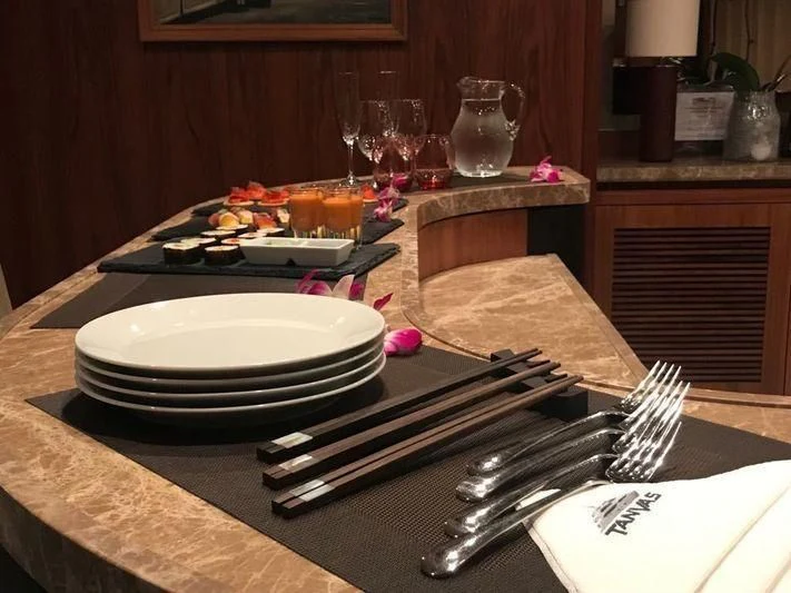 a table with plates and glasses aboard ABOUT TIME Yacht for Sale