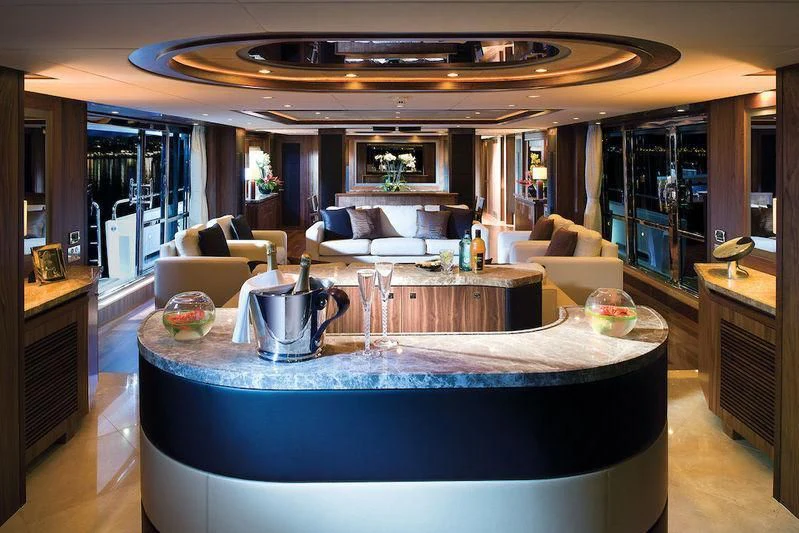 a large living room with a large round table and a large blue table aboard ABOUT TIME Yacht for Sale