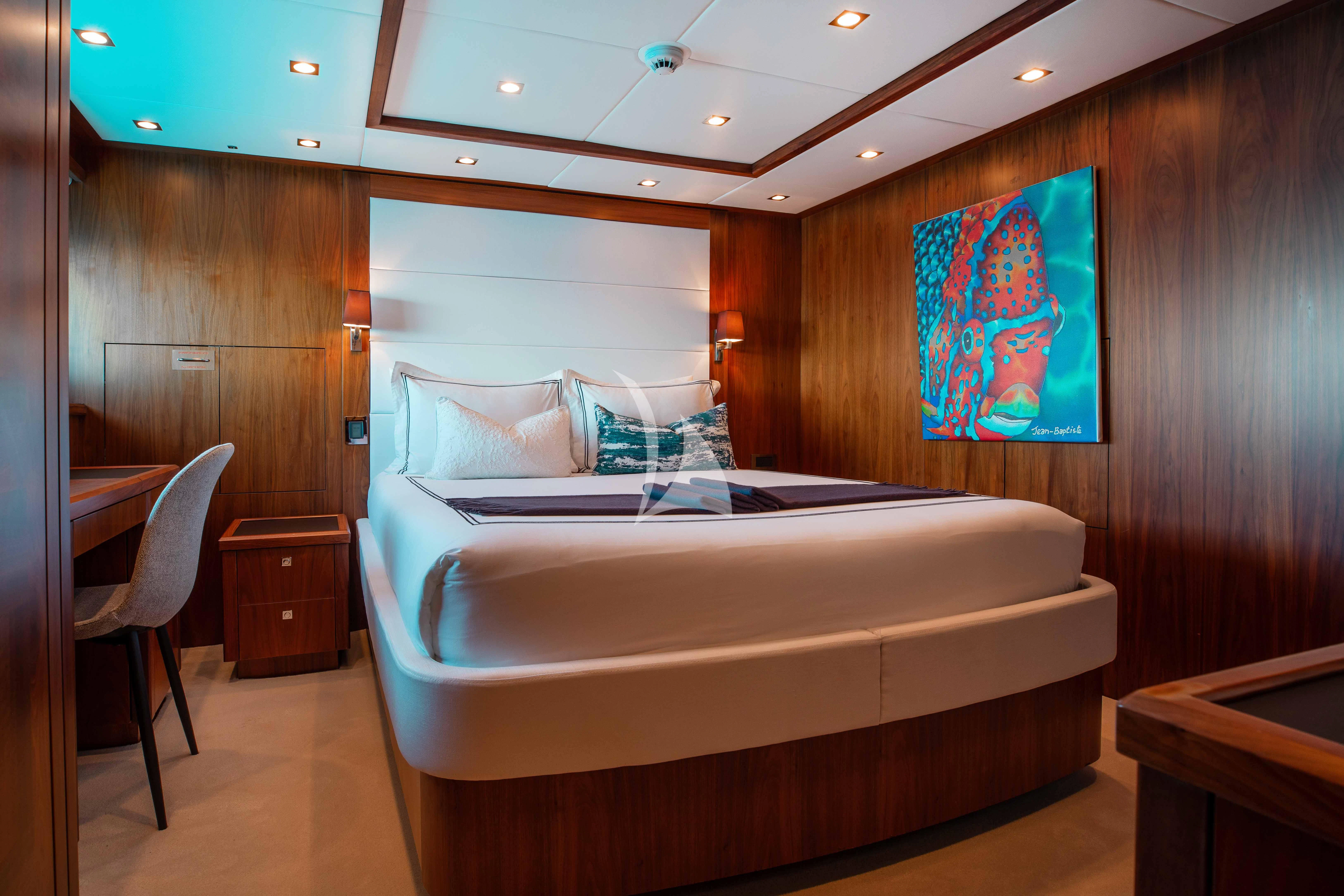 a room with a bed and a chair aboard ABOUT TIME Yacht for Sale