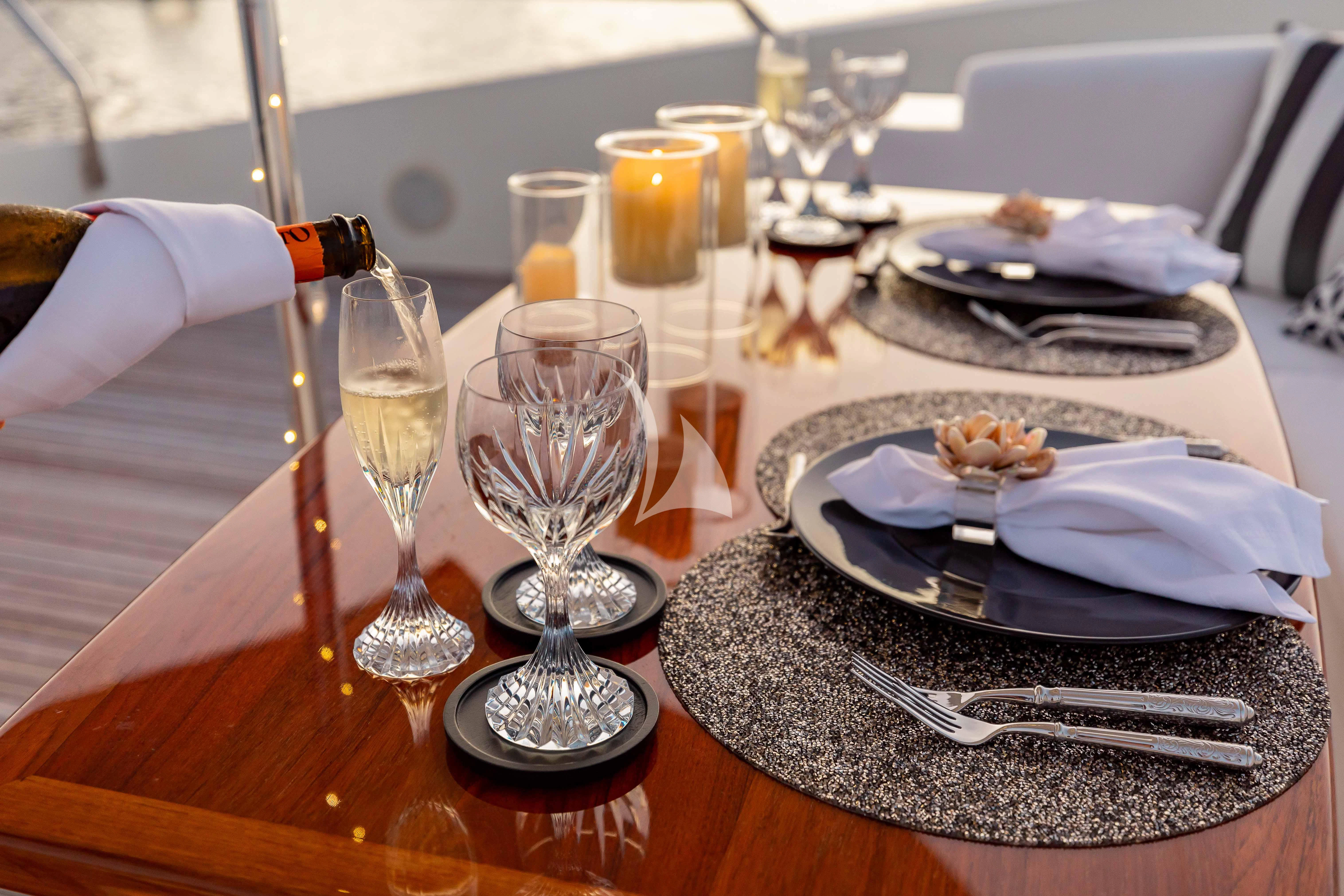a table with plates and glasses aboard ABOUT TIME Yacht for Sale