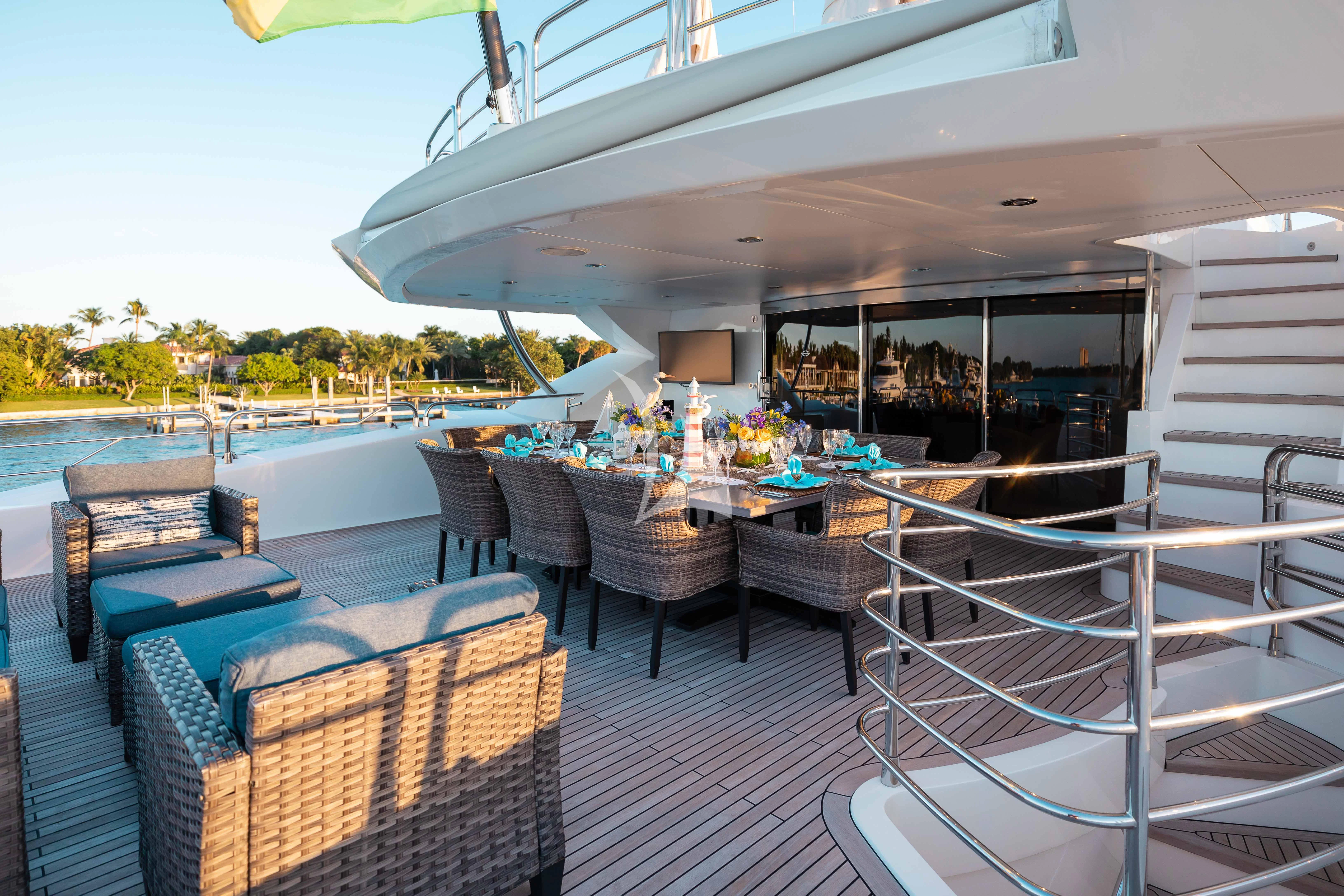 a deck with a table and chairs on it aboard ABOUT TIME Yacht for Sale