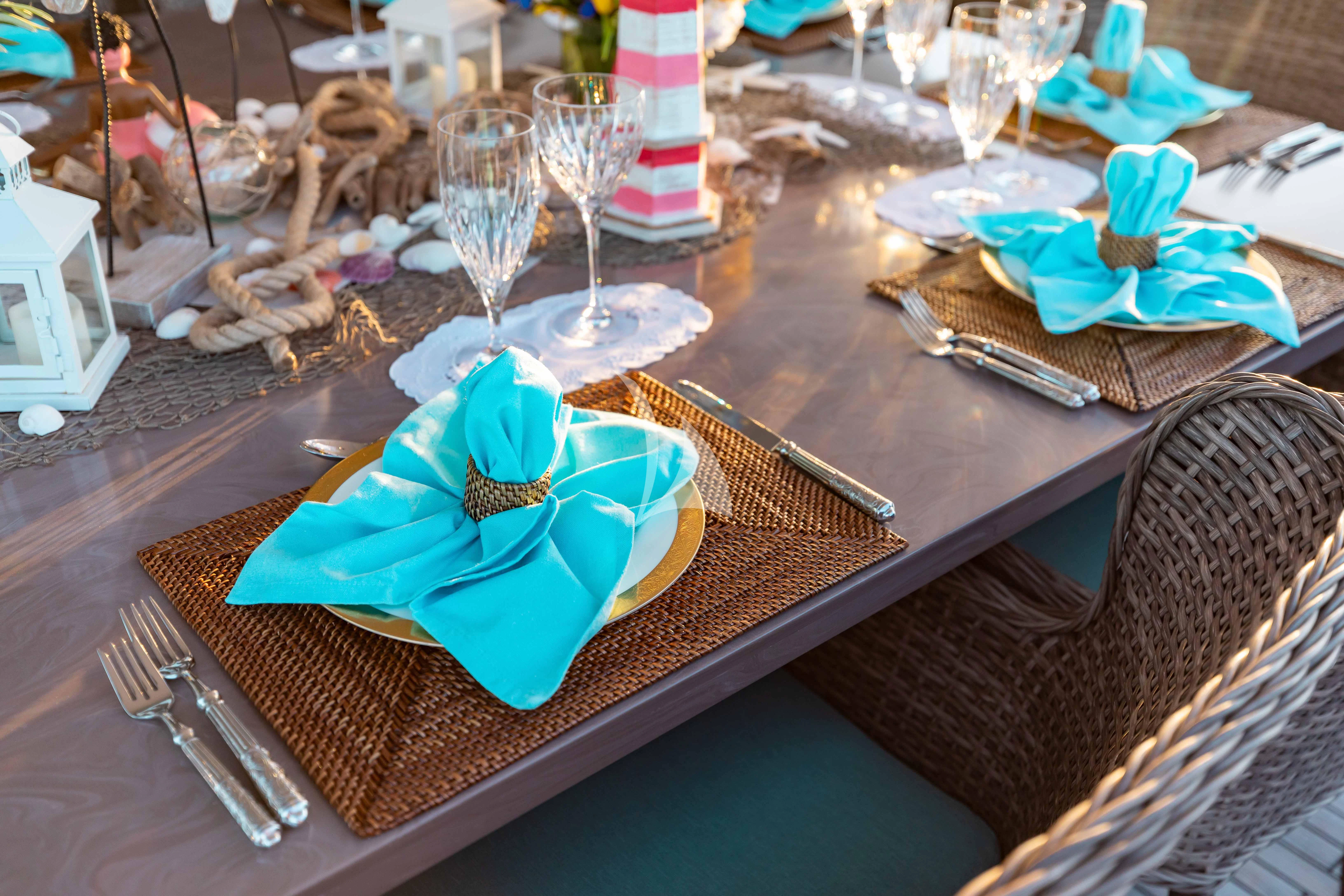 a table with a glass bowl and a plate with a blue flower on it aboard ABOUT TIME Yacht for Sale