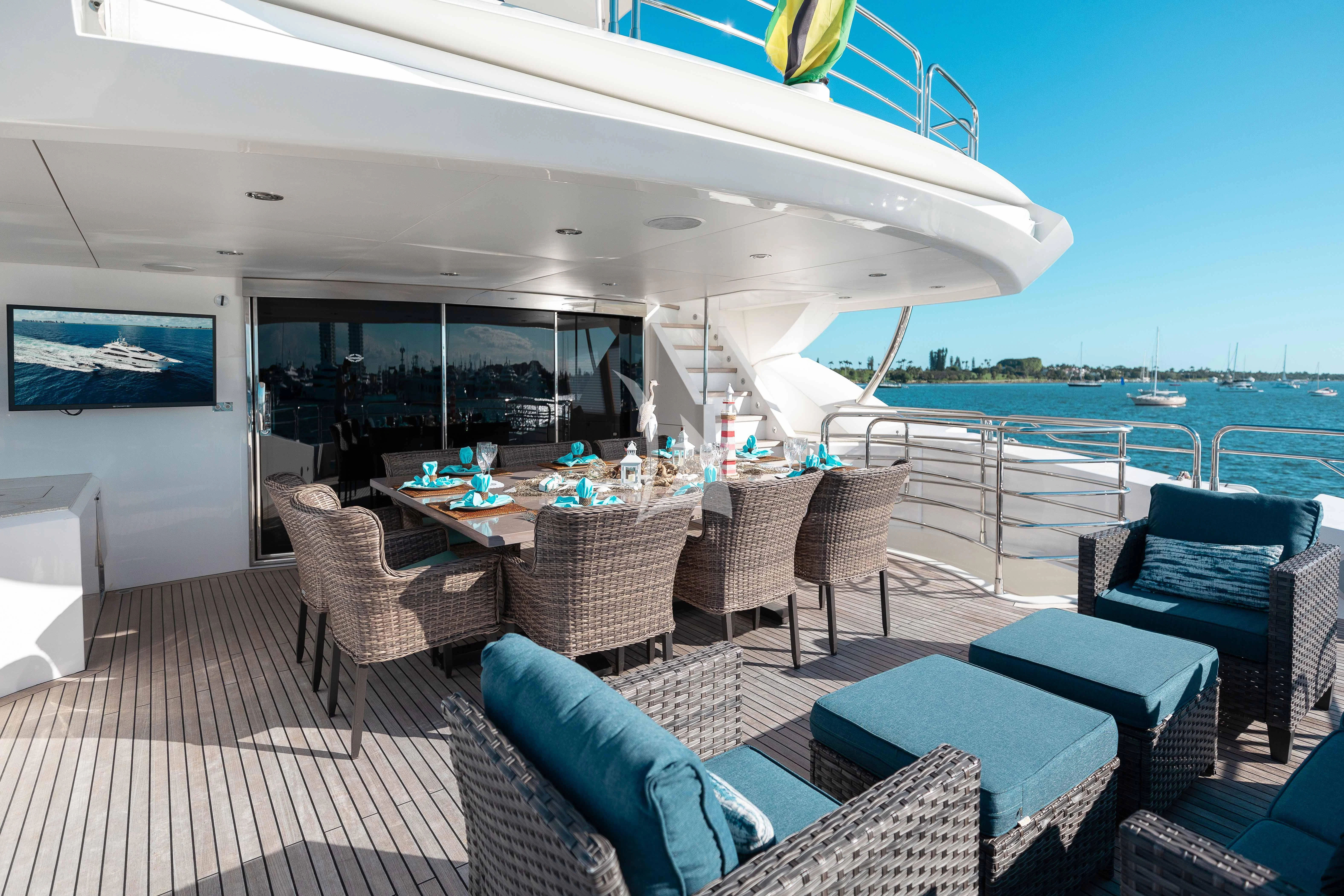 a large patio with chairs and a table and a large swimming pool aboard ABOUT TIME Yacht for Sale