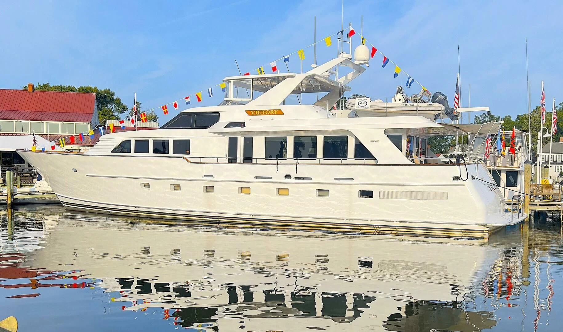 a large white boat in a harbor aboard VICTORY Yacht for Sale