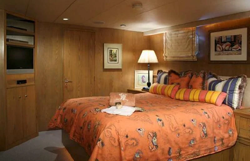 a bedroom with a bed and a television aboard VICTORY Yacht for Sale
