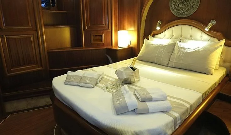 a bed with white sheets and pillows aboard KAPTAN MEHMET BUGRA Yacht for Sale