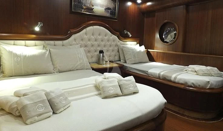 a room with a bed and a mirror aboard KAPTAN MEHMET BUGRA Yacht for Sale
