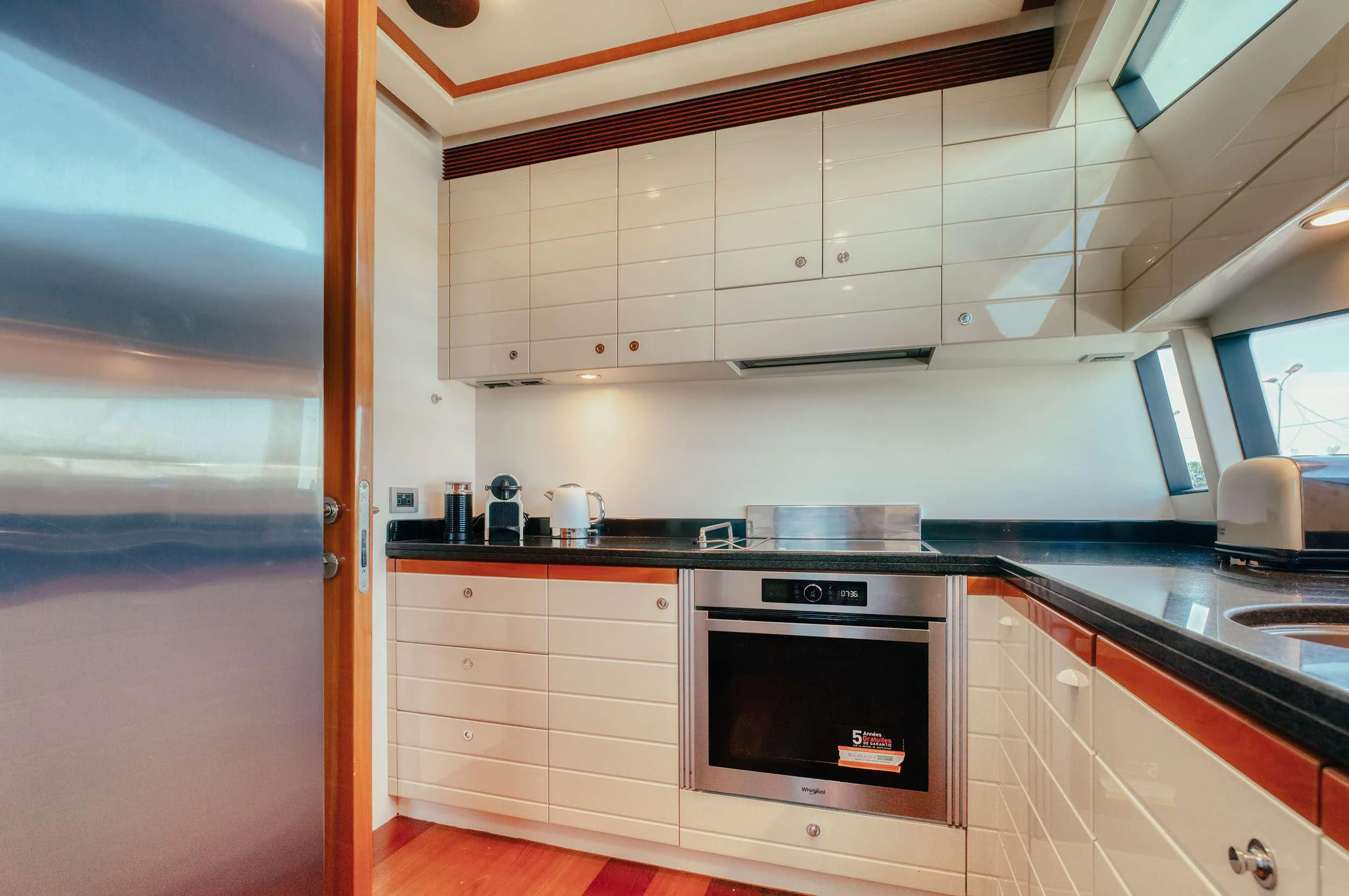 a kitchen with white cabinets aboard LIDIA Yacht for Sale