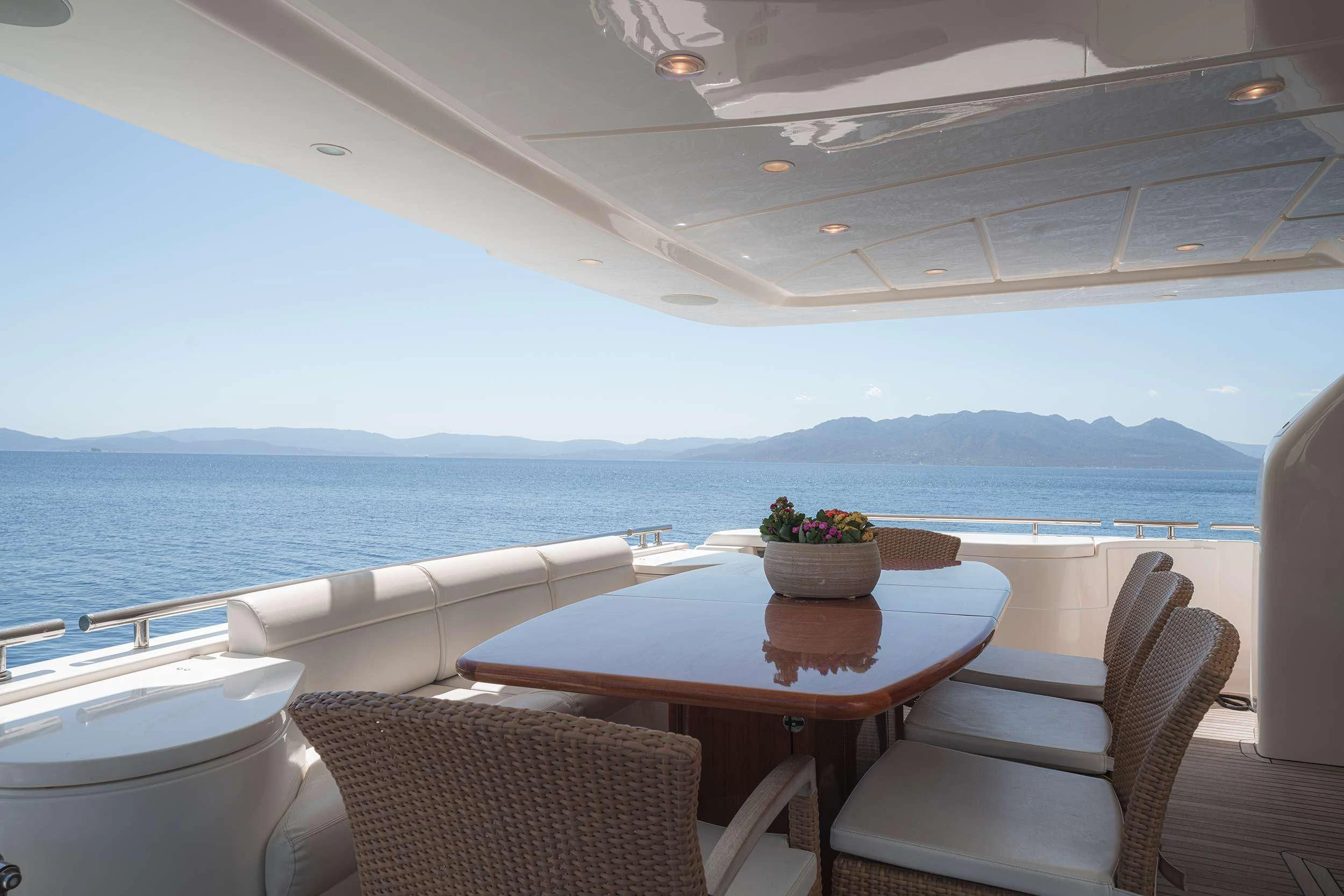 a table and chairs on a deck overlooking a body of water aboard LIDIA Yacht for Sale