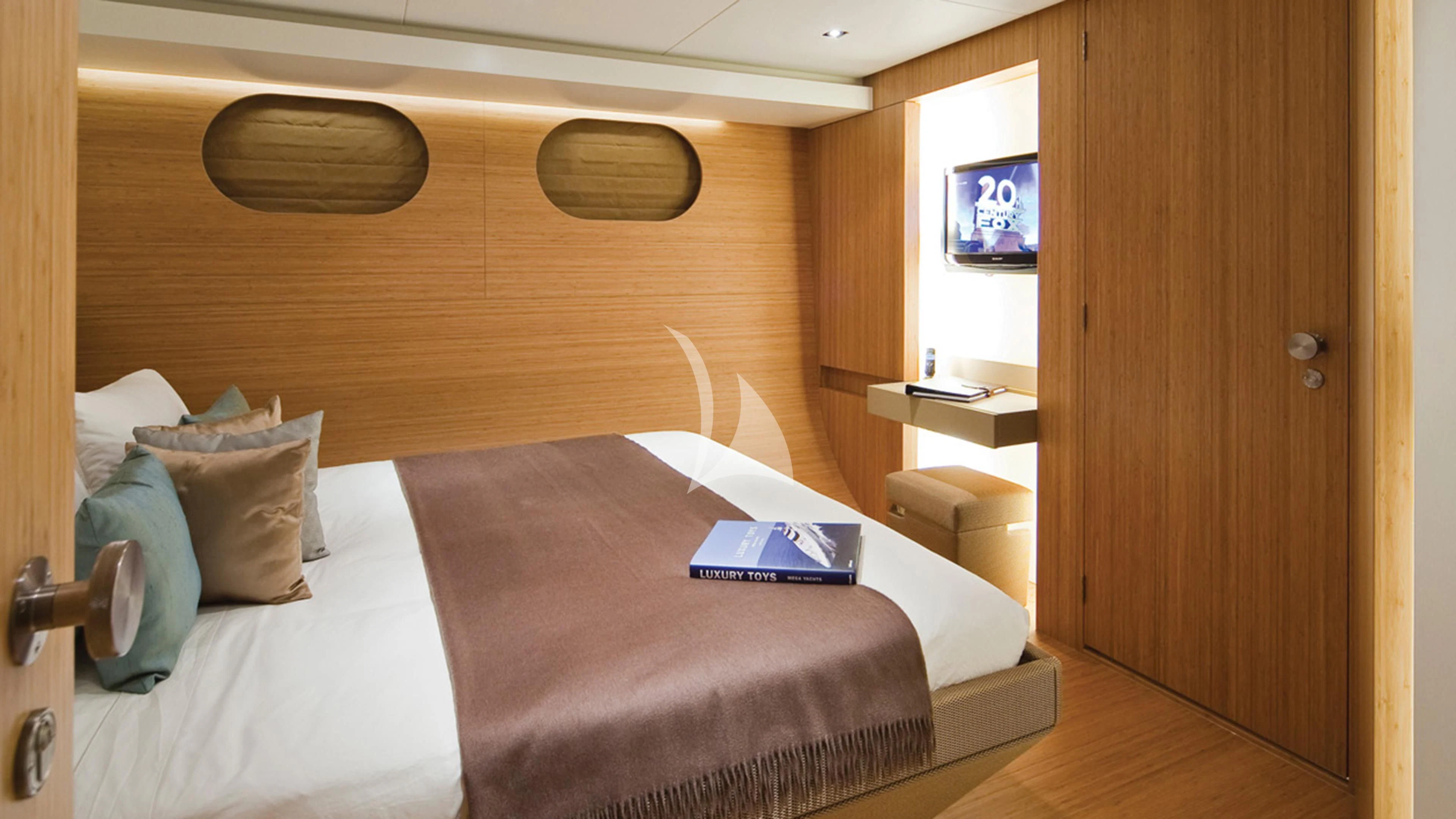 a bed with a television on the wall aboard JEMS Yacht for Sale