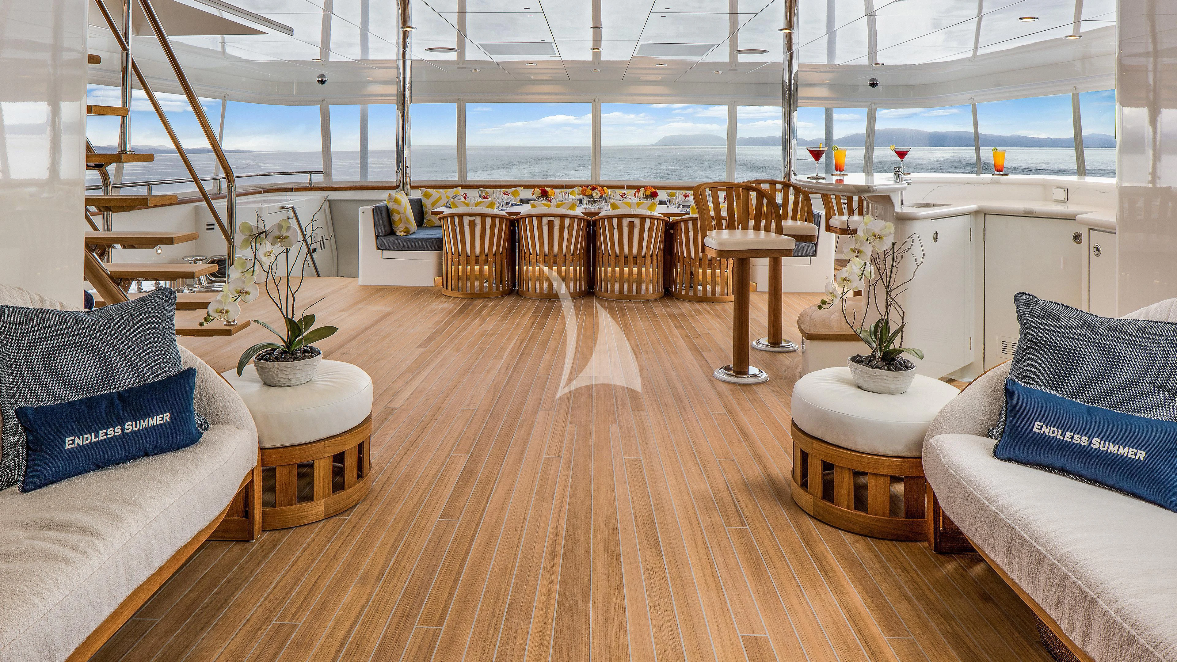 a room with a wood floor and white couches aboard ENDLESS SUMMER Yacht for Sale