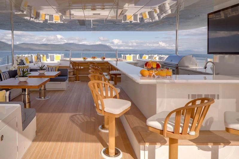 a room with a table chairs and a tv aboard ENDLESS SUMMER Yacht for Sale