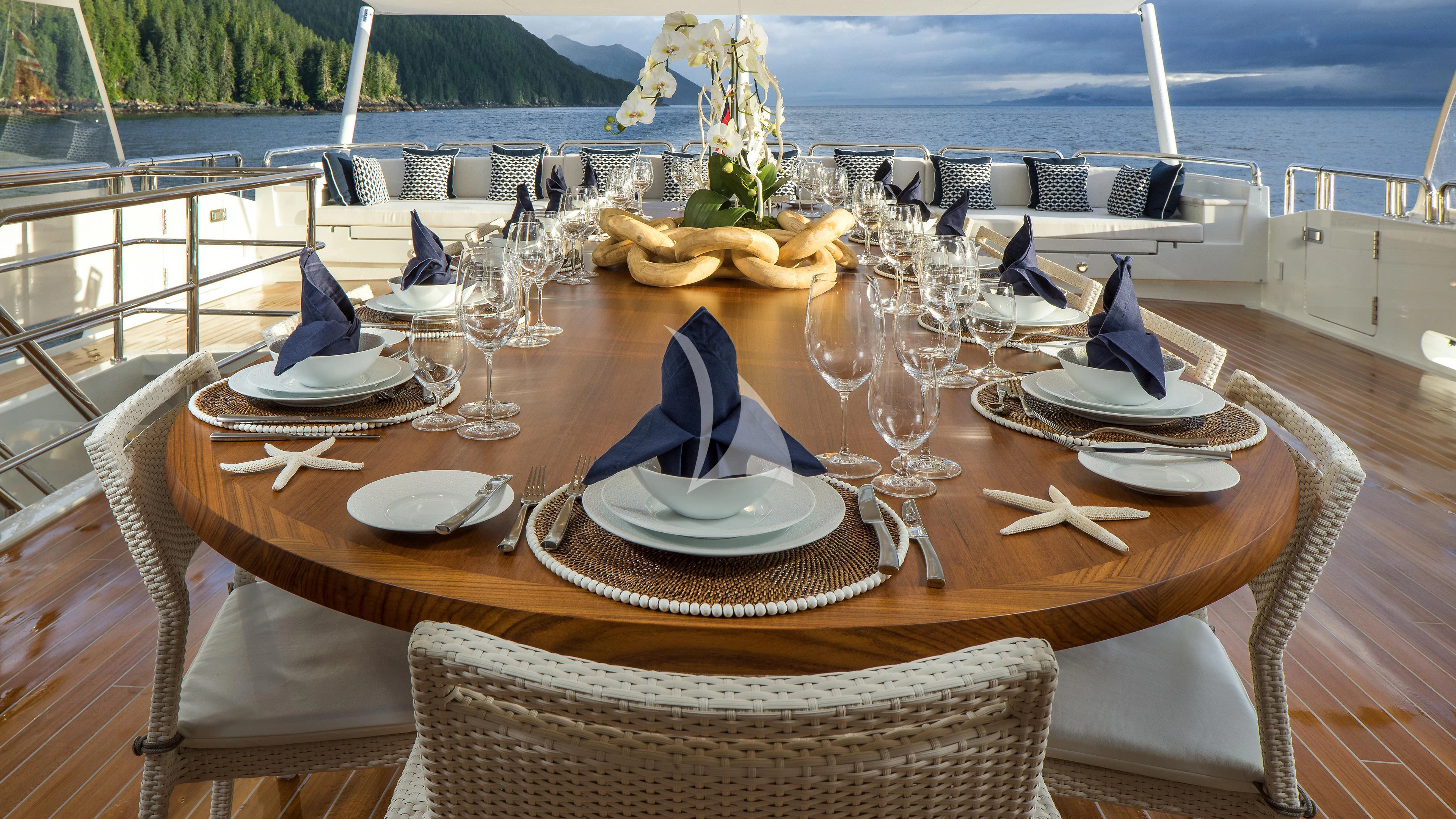 a table set with plates and glasses aboard ENDLESS SUMMER Yacht for Sale