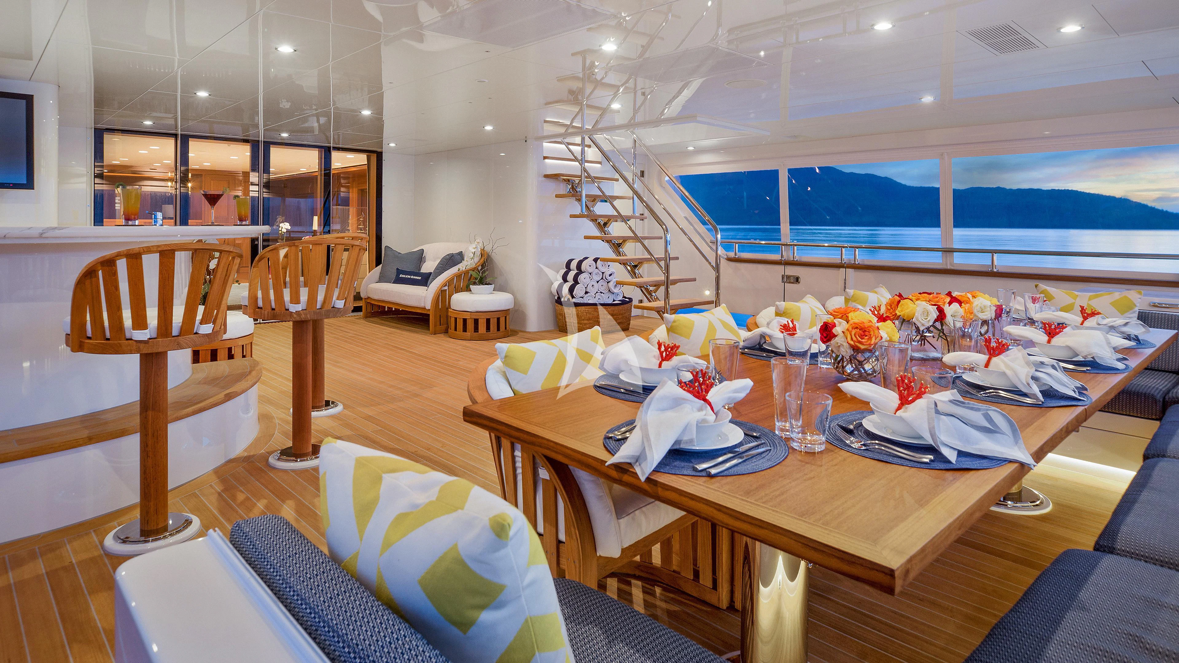 a room with a table chairs and a ladder aboard ENDLESS SUMMER Yacht for Sale