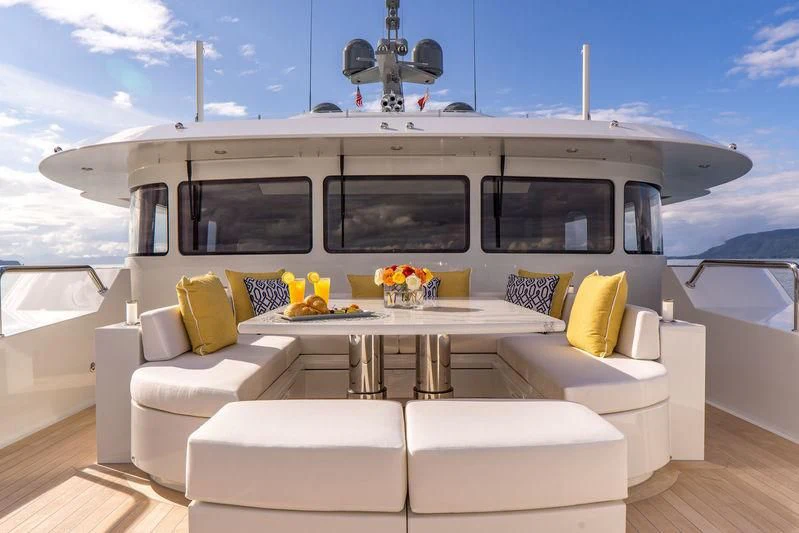 a white yacht with a table and chairs on a deck aboard ENDLESS SUMMER Yacht for Sale