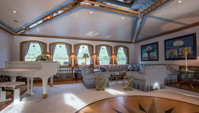 a large living room with a large table and a large window aboard GRAND OCEAN Yacht for Sale