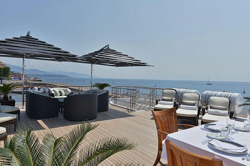 a patio with a table and chairs and umbrellas aboard LUDZIE Yacht for Sale