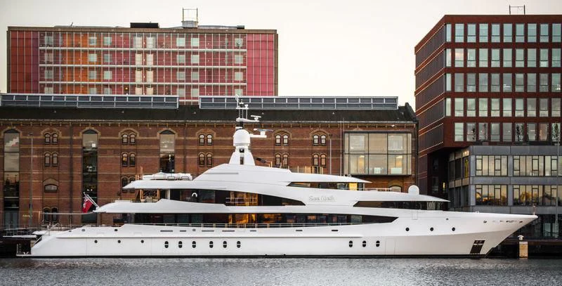 a large white boat in front of a large building aboard LUDZIE Yacht for Sale