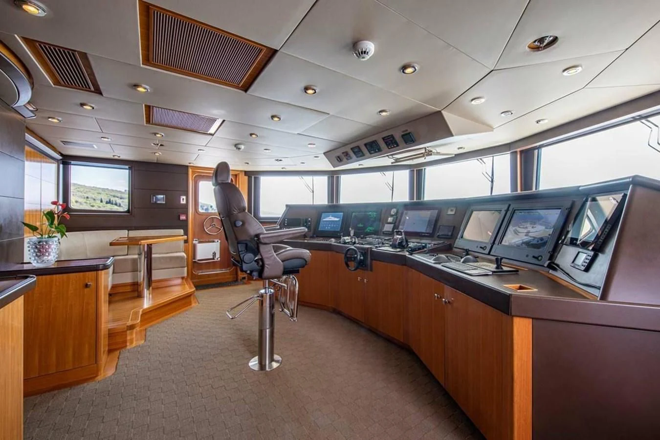 a person sitting in a chair in a room with computers and a large window aboard LUDZIE Yacht for Sale
