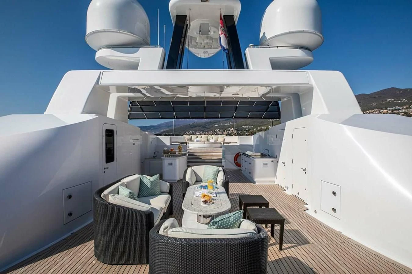 a large white building with a large white dome and a black table and chairs on a sunny day aboard LUDZIE Yacht for Sale