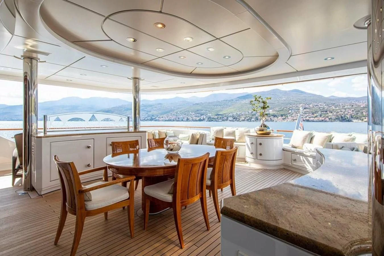 a table and chairs on a deck overlooking a body of water aboard LUDZIE Yacht for Sale