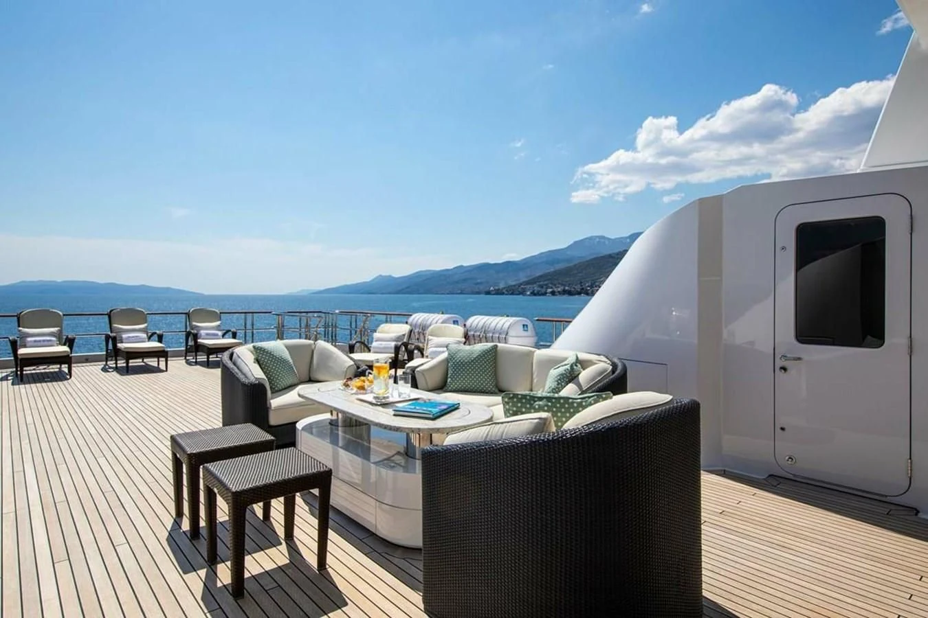 a deck with a table and chairs aboard LUDZIE Yacht for Sale