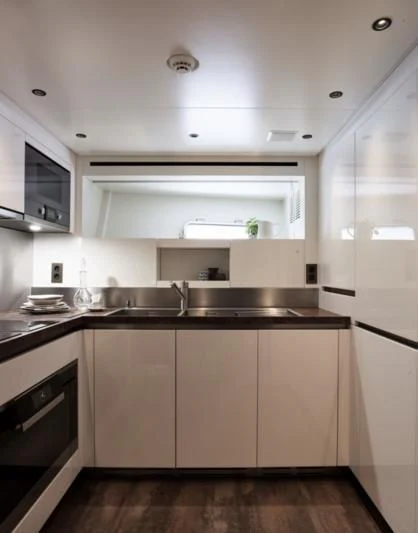 a kitchen with white cabinets aboard LUAR Yacht for Charter