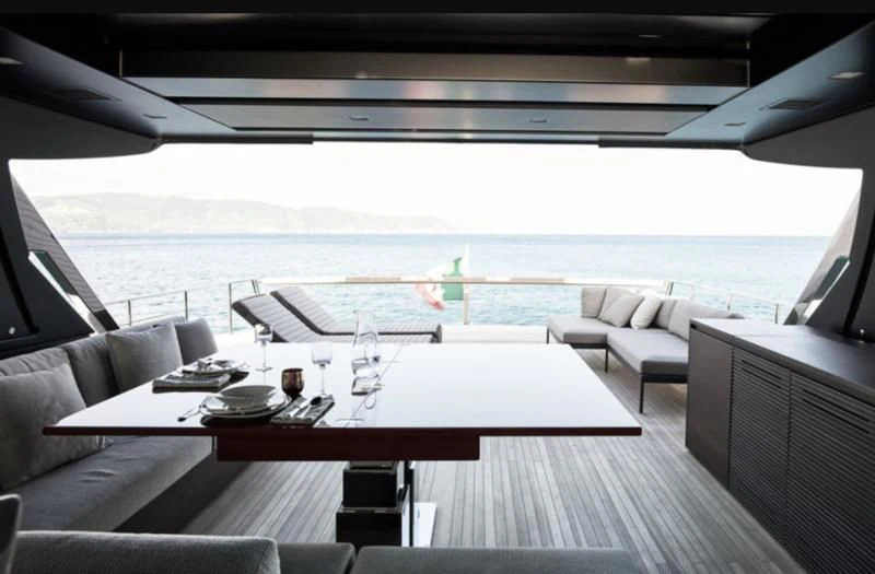 a room with a table chairs and a view of the ocean aboard LUAR Yacht for Charter