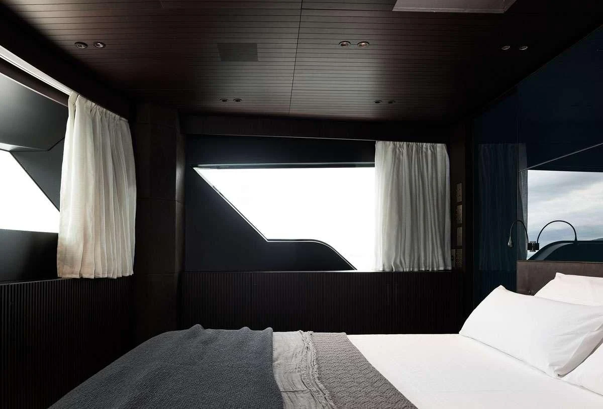 a room with a bed and a window aboard LUAR Yacht for Charter