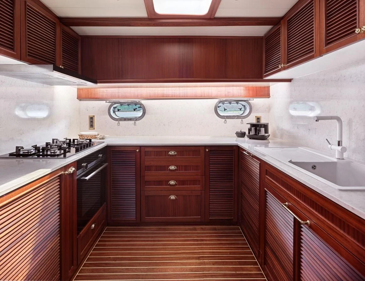 a kitchen with wooden cabinets aboard KAFTAN Yacht for Sale