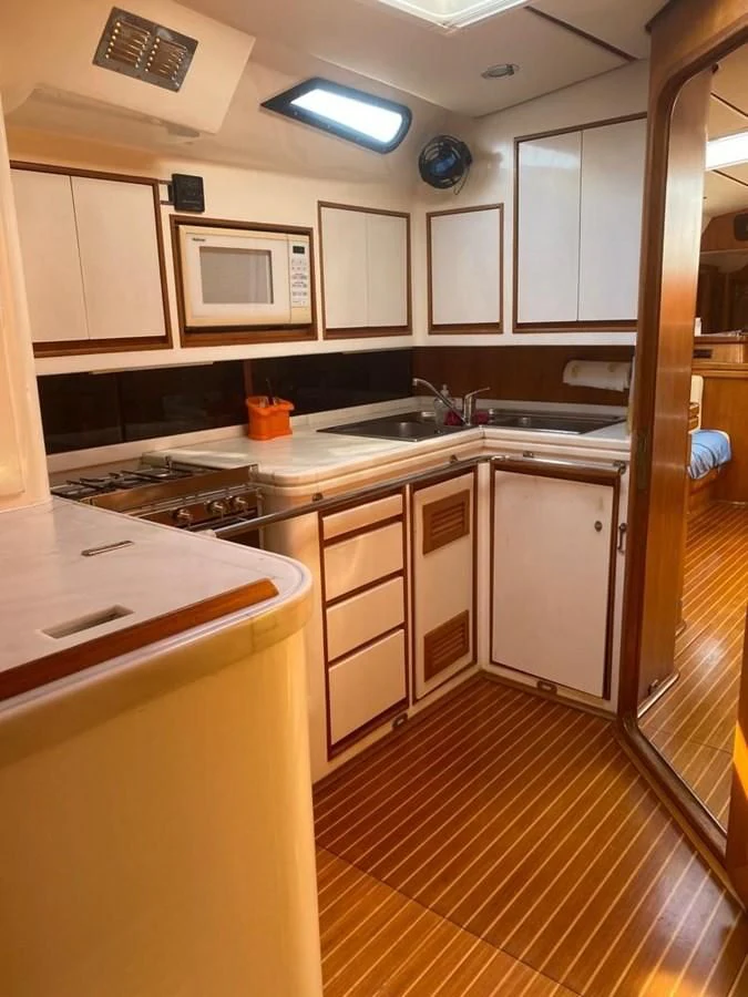 a kitchen with white cabinets aboard BLUE WING Yacht for Sale