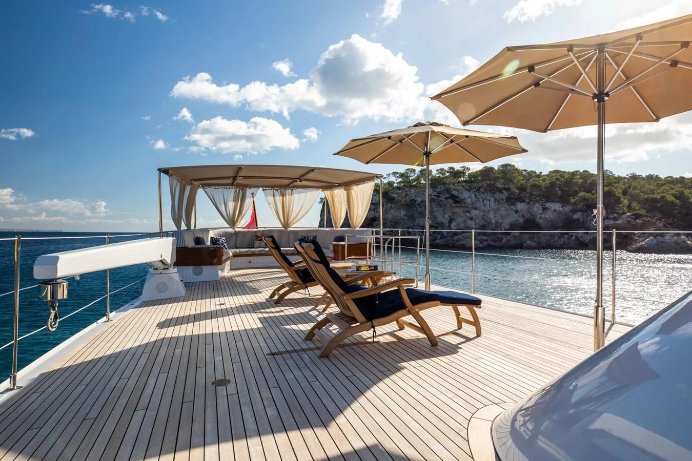 a deck with chairs and umbrellas aboard ODYSSEY III Yacht for Sale
