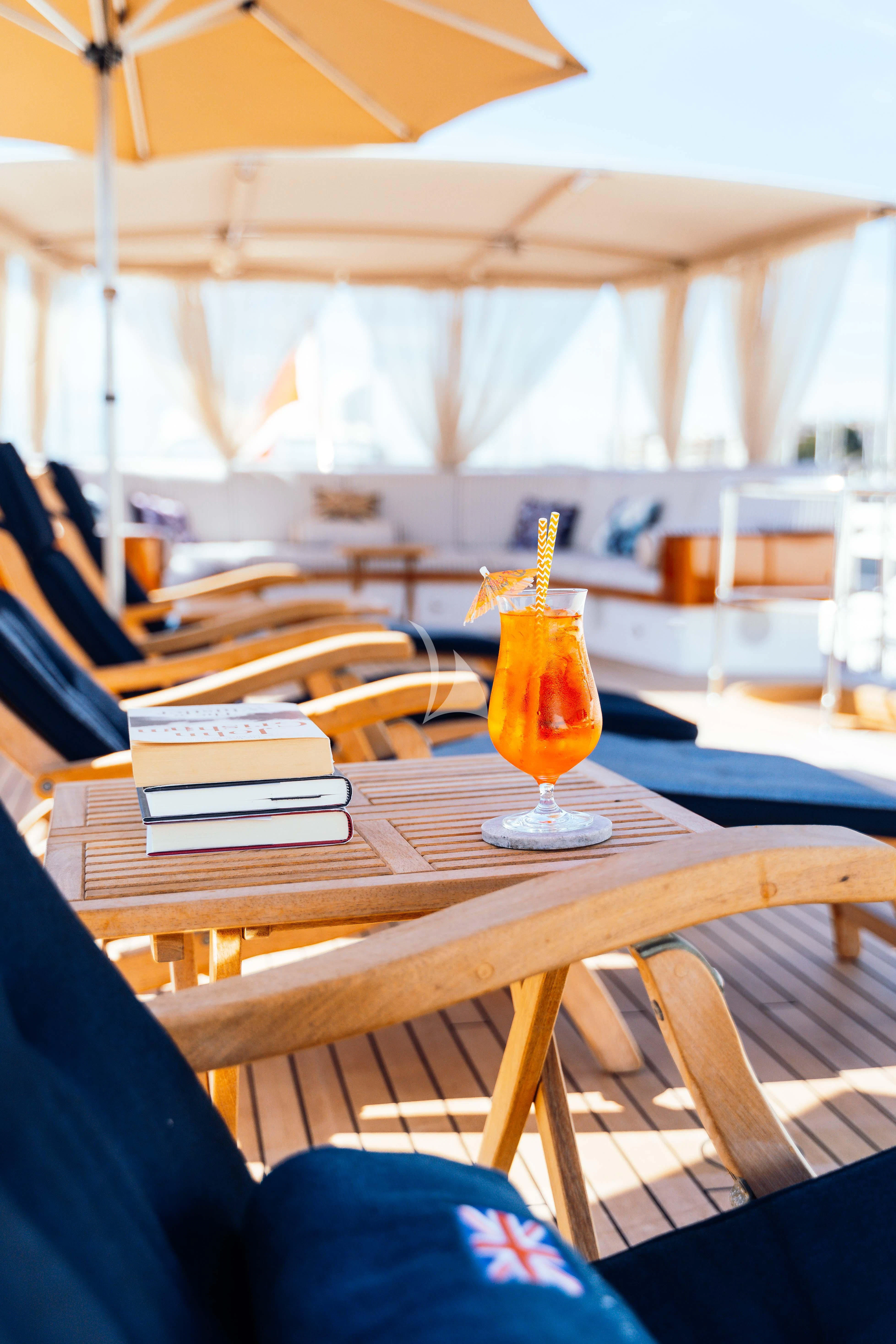 a glass of beer on a table aboard ODYSSEY III Yacht for Sale
