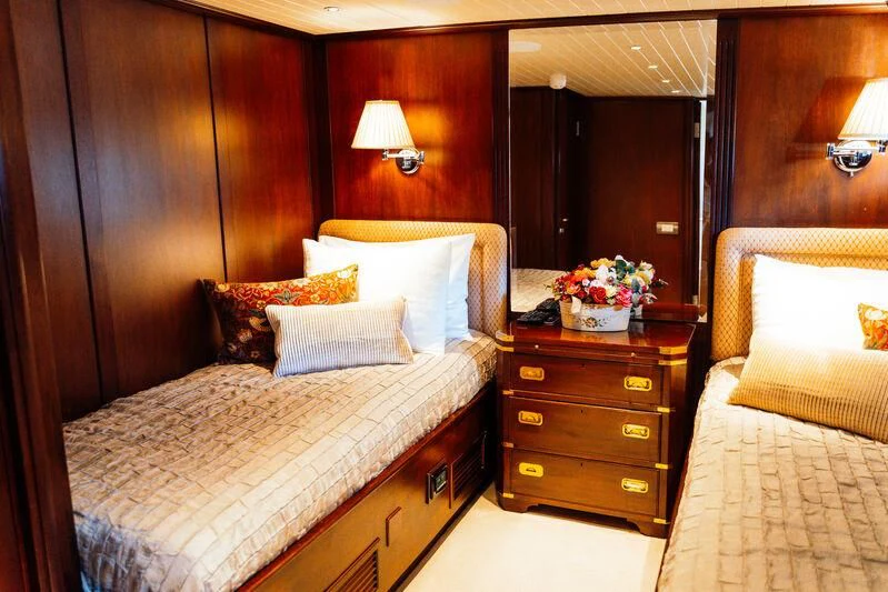 a bedroom with a bed and a dresser aboard ODYSSEY III Yacht for Sale