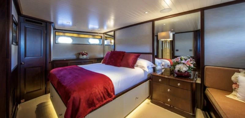 a room with a bed and a mirror aboard ODYSSEY III Yacht for Sale