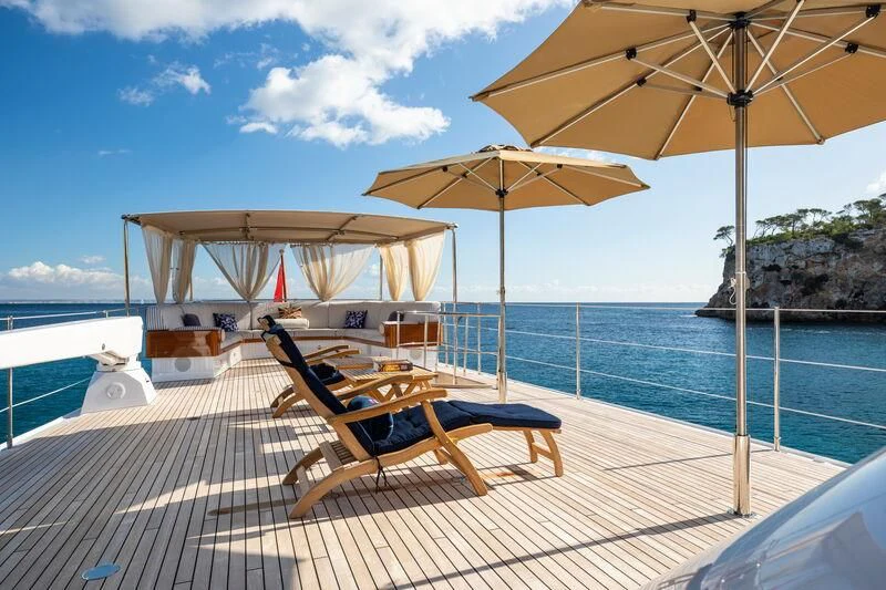 a deck with chairs and umbrellas on it aboard ODYSSEY III Yacht for Sale