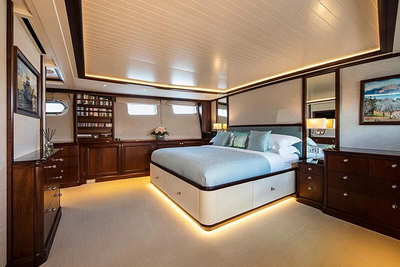 a bedroom with a bed and a bookcase aboard ODYSSEY III Yacht for Sale