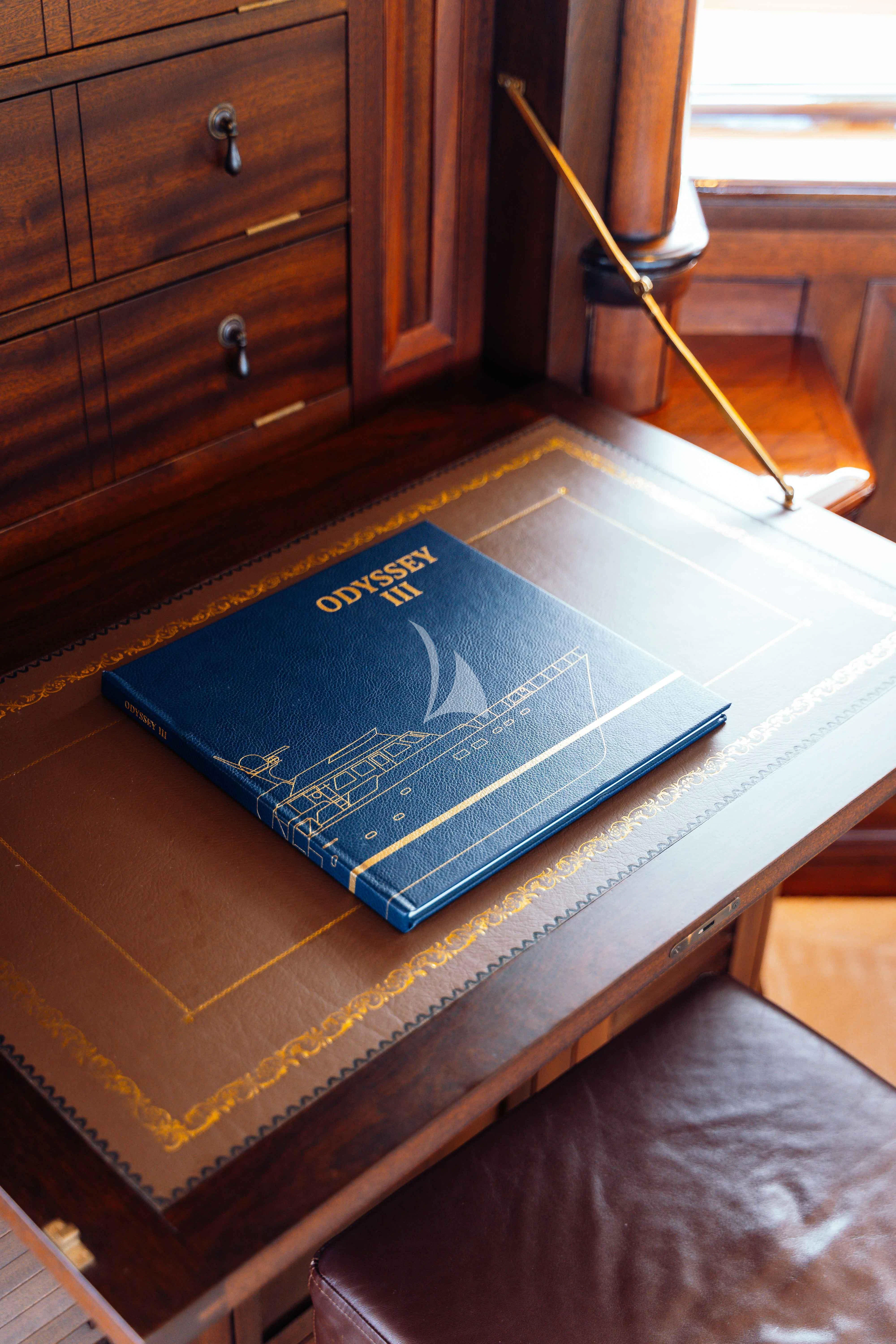 a book on a table aboard ODYSSEY III Yacht for Sale