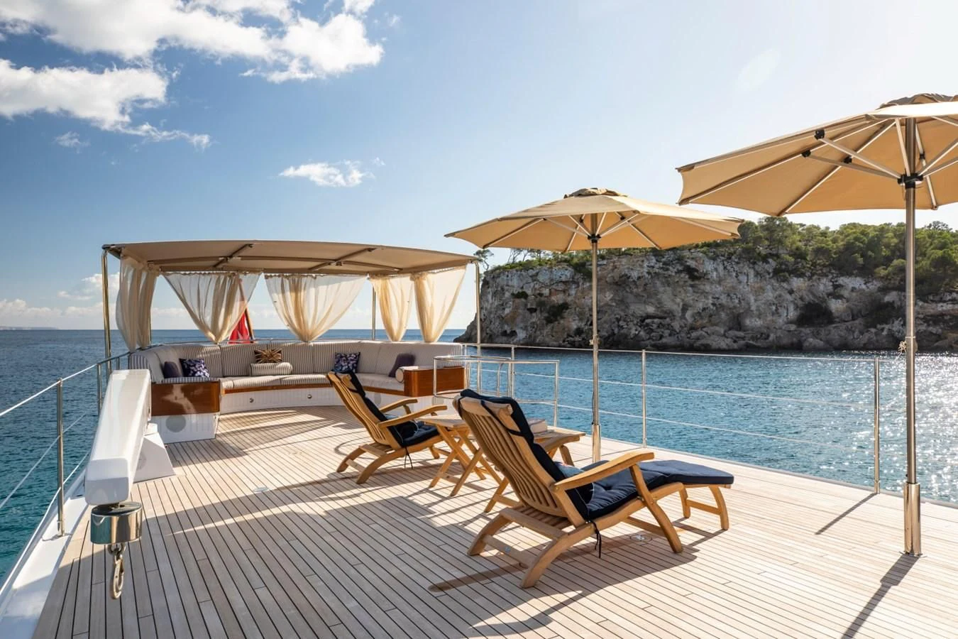 a deck with chairs and umbrellas aboard ODYSSEY III Yacht for Sale