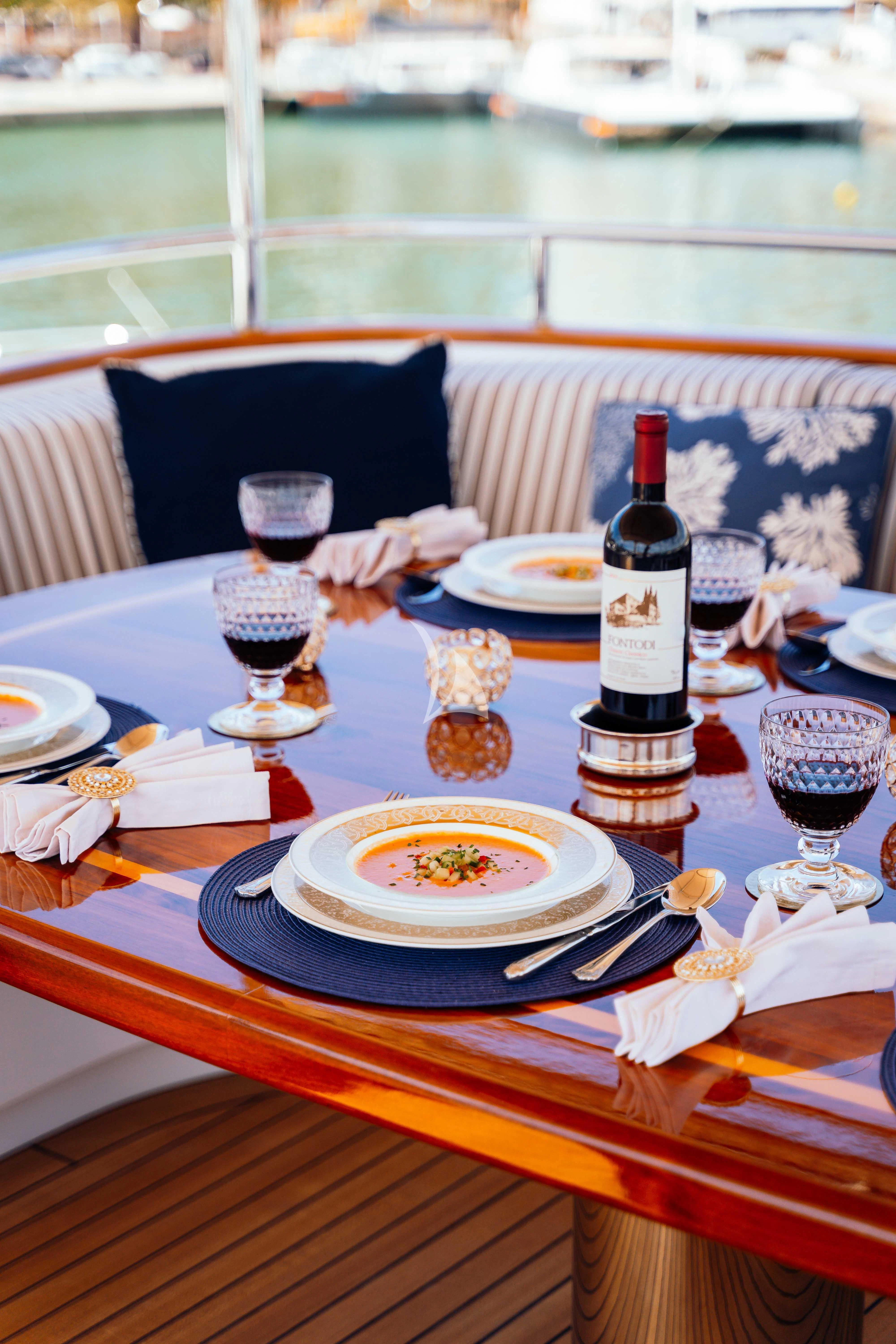 a table with plates and wine bottles aboard ODYSSEY III Yacht for Sale