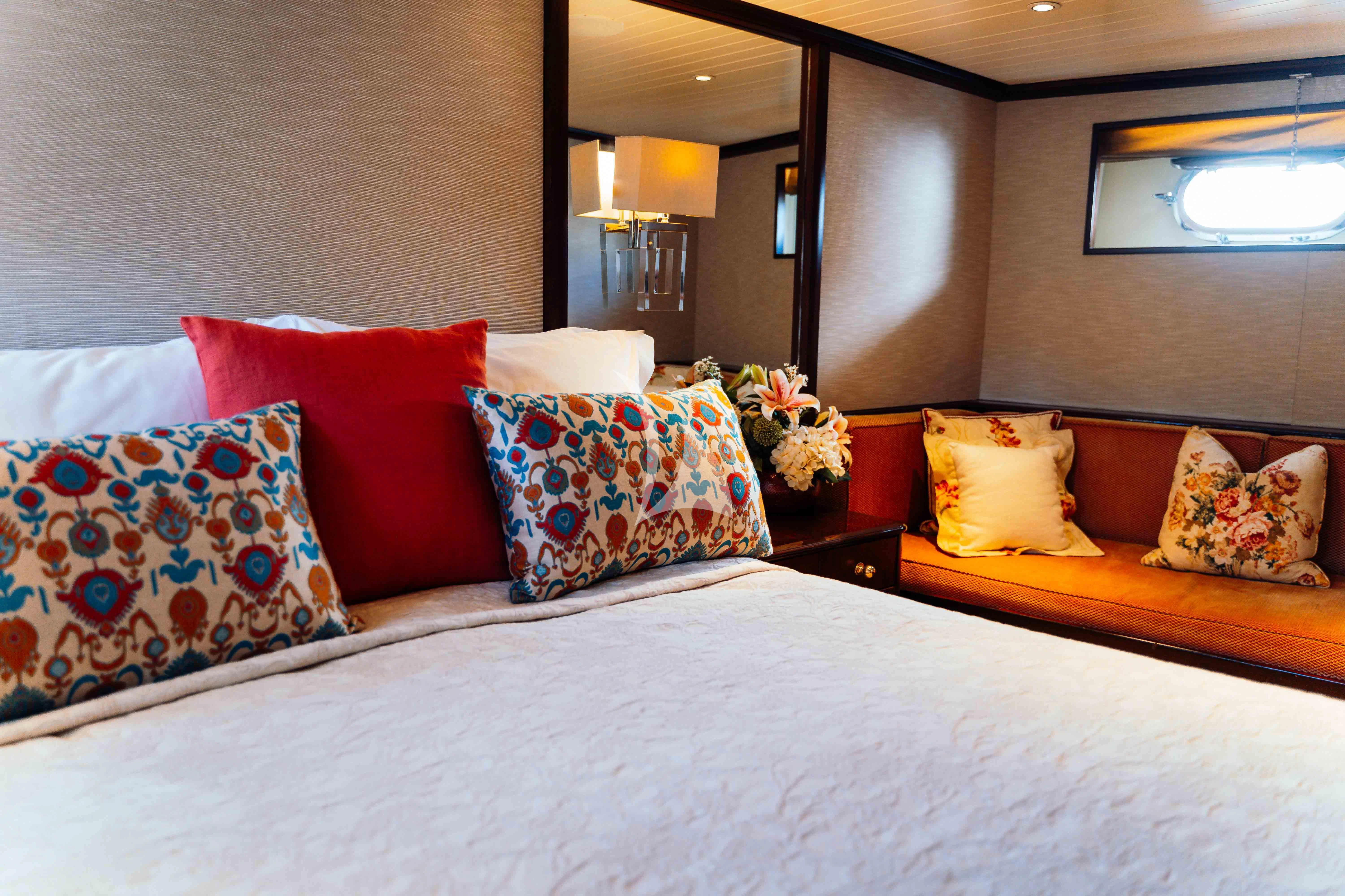 a bed with colorful pillows aboard ODYSSEY III Yacht for Sale