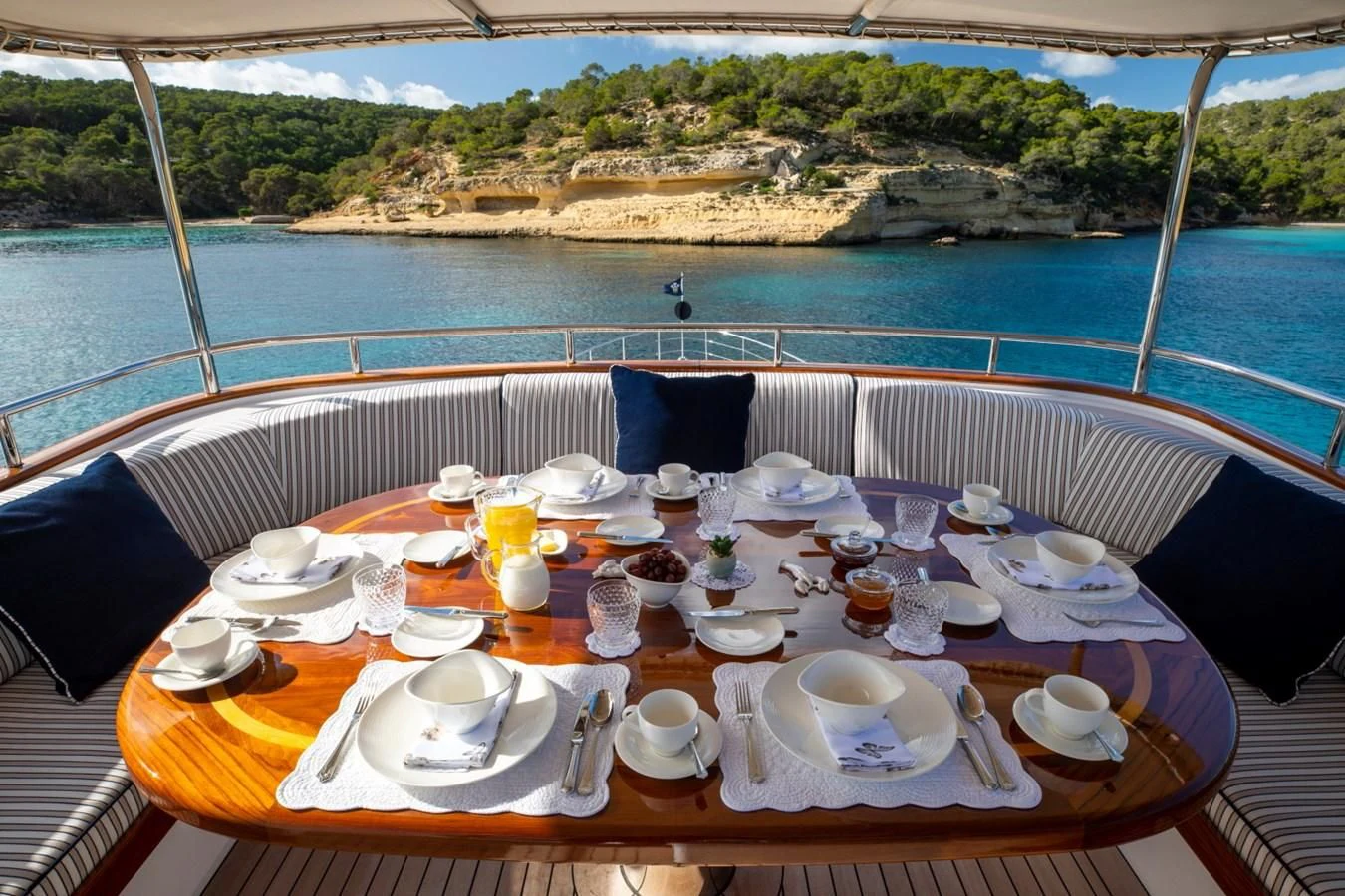 a table with plates and cups on it aboard ODYSSEY III Yacht for Sale